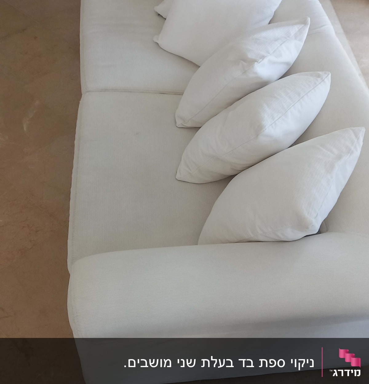 ספה לבנה עם כריות לבנות על רצפת שיש
